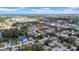 Aerial view shows the property in a neighborhood featuring a lake, trees, and nearby cityscape at 7133 Box Elder Dr, Port Richey, FL 34668