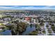 Aerial view shows the property in a neighborhood featuring a lake and nearby cityscape at 7133 Box Elder Dr, Port Richey, FL 34668