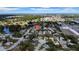 Aerial view shows the property in a neighborhood featuring a lake, trees, and nearby cityscape at 7133 Box Elder Dr, Port Richey, FL 34668
