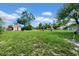 Expansive backyard featuring lush green grass, mature trees, and plenty of space for outdoor activities at 7133 Box Elder Dr, Port Richey, FL 34668