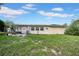 A well-maintained backyard features a patio area, lush lawn, and an outdoor dining set at 7133 Box Elder Dr, Port Richey, FL 34668