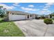 Exterior showcasing an attached two car garage, ample parking, and some landscaping at 7133 Box Elder Dr, Port Richey, FL 34668