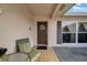 Inviting front door with outdoor seating, a decorative wreath, and a large window at 7133 Box Elder Dr, Port Richey, FL 34668