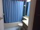Cozy bathroom featuring a shower-tub with a blue curtain and a single sink vanity at 7614 Radcliffe Cir # B213, Port Richey, FL 34668