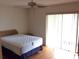 Comfortable bedroom with a ceiling fan, hardwood floors, and sliding glass doors for natural light and easy access to the outdoors at 7614 Radcliffe Cir # B213, Port Richey, FL 34668