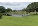 Scenic pond with fountain feature and lush green lawn, providing a tranquil and picturesque setting in the community at 7614 Radcliffe Cir # B213, Port Richey, FL 34668