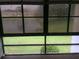 View of a lake and green grass from a room with large grid windows at 7614 Radcliffe Cir # B213, Port Richey, FL 34668