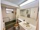 Bathroom featuring a single sink vanity, tiled walls, tub with grab bar, and medicine cabinet at 8312 Split Rail Ln, Hudson, FL 34667