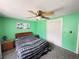 Bedroom features green walls, fan, closet, and comfortable bed creating a cozy and inviting space at 8312 Split Rail Ln, Hudson, FL 34667