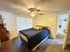 Bright bedroom featuring a ceiling fan, large window, and a comfortable bed with blue comforter at 8312 Split Rail Ln, Hudson, FL 34667