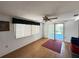 Bright living room with wood floors, vertical blinds, fan, and access to outdoor area at 8312 Split Rail Ln, Hudson, FL 34667