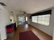Well-lit living room featuring wood floors, fan, large windows, and access to sunroom at 8312 Split Rail Ln, Hudson, FL 34667
