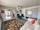 Spacious sun room with white walls, fan, desk, seating, and leafy rug creating a relaxed atmosphere at 8312 Split Rail Ln, Hudson, FL 34667