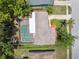 Aerial view of a home featuring a screened pool, spacious backyard, and a well-maintained roof at 8404 Fishhawk Ave, New Port Richey, FL 34653