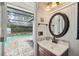 Bathroom with view of pool area featuring a single vanity and mirror at 8404 Fishhawk Ave, New Port Richey, FL 34653
