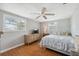 Cozy bedroom featuring hardwood floors, ceiling fan and large window with exterior views at 8404 Fishhawk Ave, New Port Richey, FL 34653