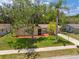 Inviting single-story home featuring a lush green lawn, mature trees, and a convenient driveway leading to the garage at 8404 Fishhawk Ave, New Port Richey, FL 34653