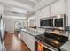 White kitchen with stainless steel microwave, dark countertop and a view to the dining area at 8404 Fishhawk Ave, New Port Richey, FL 34653