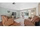 Inviting living room featuring hardwood floors, a cozy fireplace, and a glimpse of the outdoor pool at 8404 Fishhawk Ave, New Port Richey, FL 34653