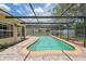 View of outdoor pool and patio with enclosed screening at 8404 Fishhawk Ave, New Port Richey, FL 34653