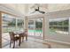 Light-filled sunroom with views of the pool, tile floors, and a ceiling fan at 8404 Fishhawk Ave, New Port Richey, FL 34653