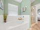 Bright bathroom with a soaking tub, walk-in shower, and large window at 8457 Southern Charm Cir, Brooksville, FL 34613