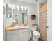 Well-lit bathroom featuring a vanity sink, toilet, and a shower with stylish patterned curtain at 8457 Southern Charm Cir, Brooksville, FL 34613