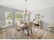 Bright dining room with a chandelier, a wooden table, and views of the landscaped yard at 8457 Southern Charm Cir, Brooksville, FL 34613