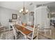 Elegant dining room leading to the kitchen with a wooden table, decorative rug and chandelier at 8457 Southern Charm Cir, Brooksville, FL 34613