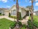 Inviting single-story home with lovely landscaping, brick walkway, and charming curb appeal at 8457 Southern Charm Cir, Brooksville, FL 34613