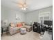 Comfortable living room features a sofa, ceiling fan, and a compact workstation near a bright window at 8457 Southern Charm Cir, Brooksville, FL 34613