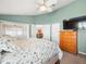 The main bedroom has access to the lanai and includes a ceiling fan and TV at 8457 Southern Charm Cir, Brooksville, FL 34613