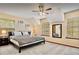 Well-lit bedroom with neutral tones, featuring a cozy bed, carpeted floors and two large windows at 952 Coachlight Ln, Brooksville, FL 34601