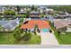 Aerial view of a lovely home with a red tile roof, a two car garage and lush landscaping at 9921 San Mateo Way, Port Richey, FL 34668
