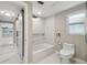 Modern bathroom featuring tub with sleek white marble surround and a sliding barn door at 9921 San Mateo Way, Port Richey, FL 34668