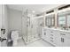 Bathroom featuring a glass shower enclosure, double sink vanity with marble countertops and modern fixtures at 9921 San Mateo Way, Port Richey, FL 34668