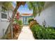 Inviting front entrance with lush landscaping, a stone walkway and a turquoise door at 9921 San Mateo Way, Port Richey, FL 34668