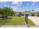 Landscaped front yard of home features lush green lawn, mature palm trees and stone accents at 9921 San Mateo Way, Port Richey, FL 34668
