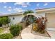 Charming walkway leads to the front courtyard, adorned with lush landscaping and stone accents at 9921 San Mateo Way, Port Richey, FL 34668