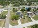 An aerial view shows the house with a long drive in a neighborhood, with other houses and many trees at 10091 Bannister St, Spring Hill, FL 34608