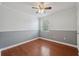 A clean and simple bedroom features durable hardwood flooring and a neutral two-tone paint scheme at 10091 Bannister St, Spring Hill, FL 34608