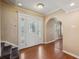 Bright entryway featuring hardwood floors, decorative front door, and stairway access at 10091 Bannister St, Spring Hill, FL 34608
