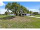 The house has a large front yard with two shade trees and a long driveway to a two-car garage at 10091 Bannister St, Spring Hill, FL 34608