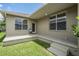 Covered back porch with neutral color stucco and green grass at 10115 Ringling St, New Port Richey, FL 34655