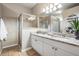 Bathroom with granite countertops, double sinks, shower, tile floors, and decorative shelving at 10115 Ringling St, New Port Richey, FL 34655