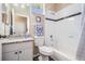 Bright bathroom featuring a granite vanity, bathtub, and white tile with a dark accent stripe at 10115 Ringling St, New Port Richey, FL 34655