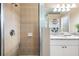 Modern bathroom with a glass-enclosed shower, double sinks, granite countertops, and tile flooring at 10115 Ringling St, New Port Richey, FL 34655
