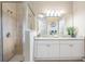 Well-lit bathroom featuring double sinks with granite countertops, a glass shower, and tile flooring at 10115 Ringling St, New Port Richey, FL 34655