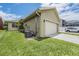View of attached two car garage with green grass and a vehicle at 10115 Ringling St, New Port Richey, FL 34655