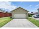 View of attached two car garage with long driveway and green grass at 10115 Ringling St, New Port Richey, FL 34655
